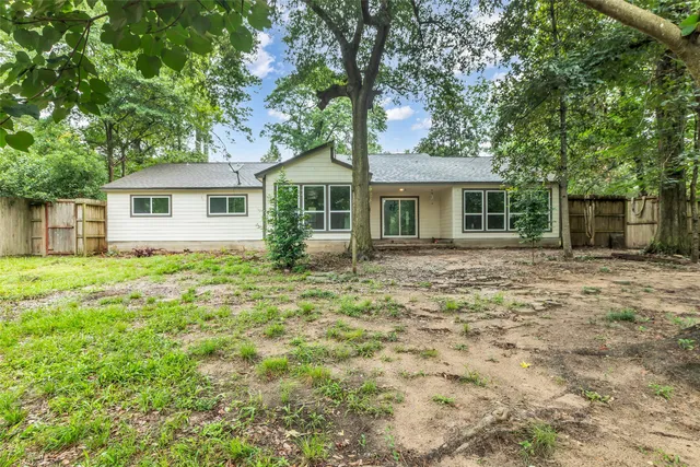 an empty room with wooden floor ceiling fan and window