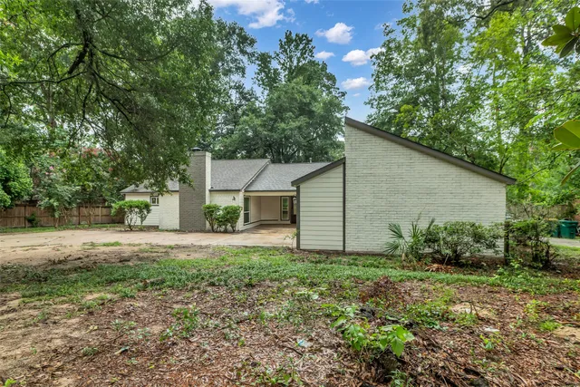 a front view of house with yard and trees around