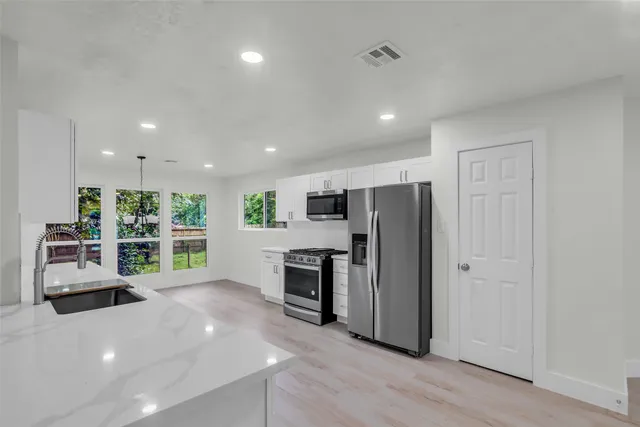 a kitchen with stainless steel appliances a stove sink and cabinets