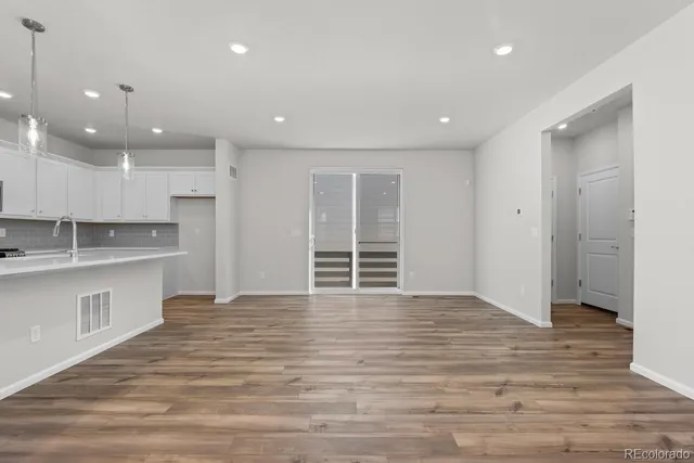 a view of an empty room with a window and bathroom