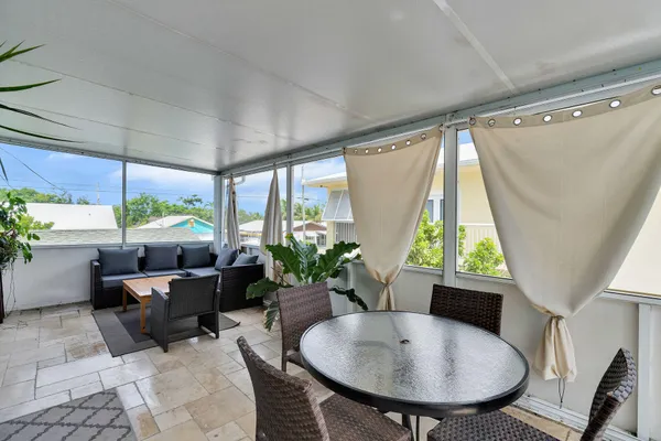 a dining room with furniture and a large window