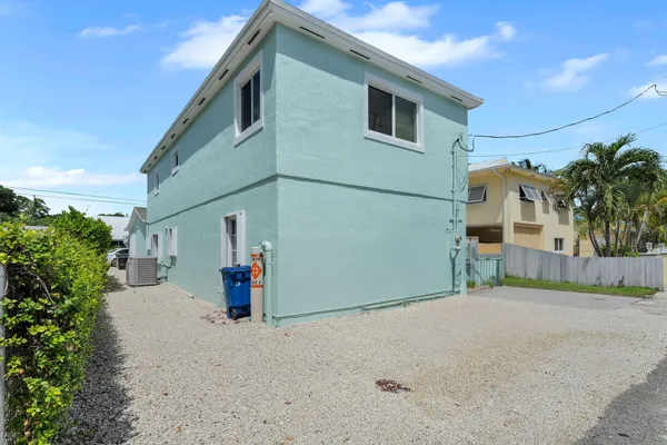 an aerial view of residential houses with outdoor space and ocean view