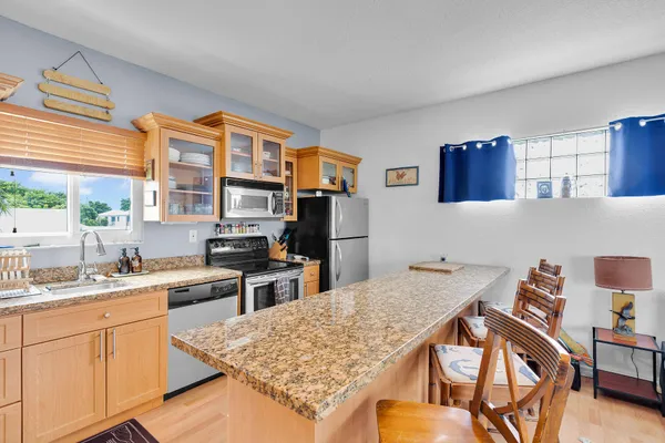 a living room with furniture kitchen view and a window