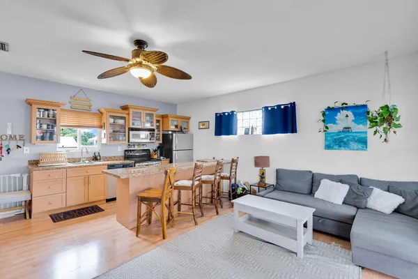 a kitchen with a table chairs and a ceiling fan