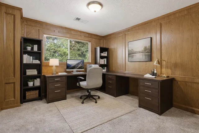 a view of a workspace with furniture and a window