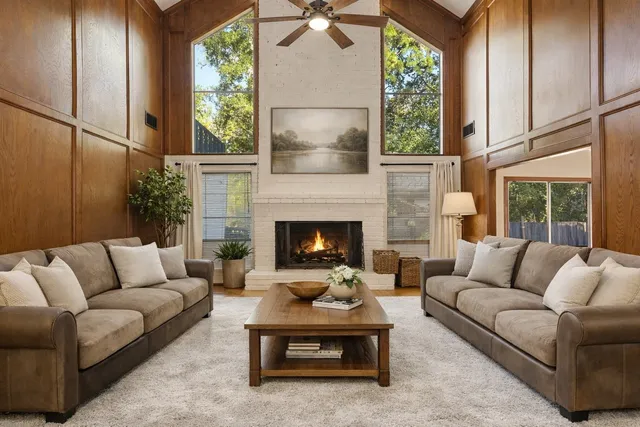 a living room with furniture fireplace and a large window
