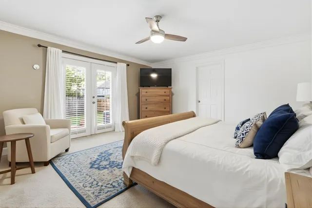 a bedroom with a bed a chair and a large window