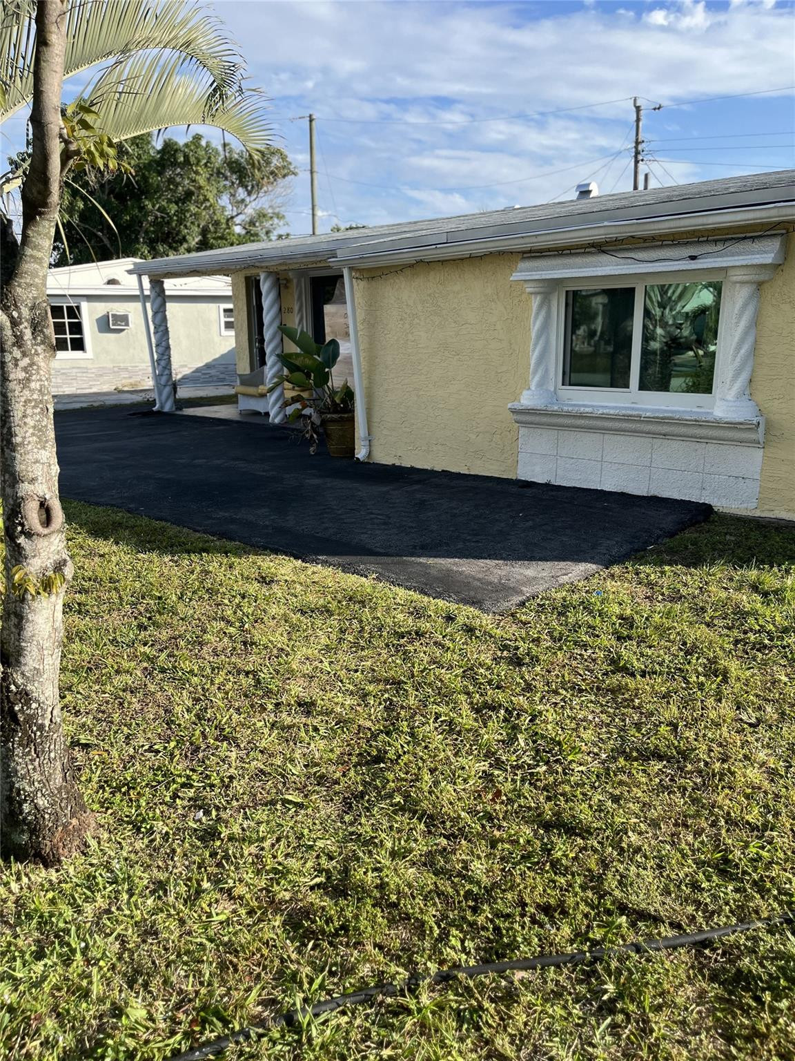 280 Northeast 23rd Street Pompano Beach, FL 33060 - Photo 10 of 12 a view of a house with a large window and wooden fence