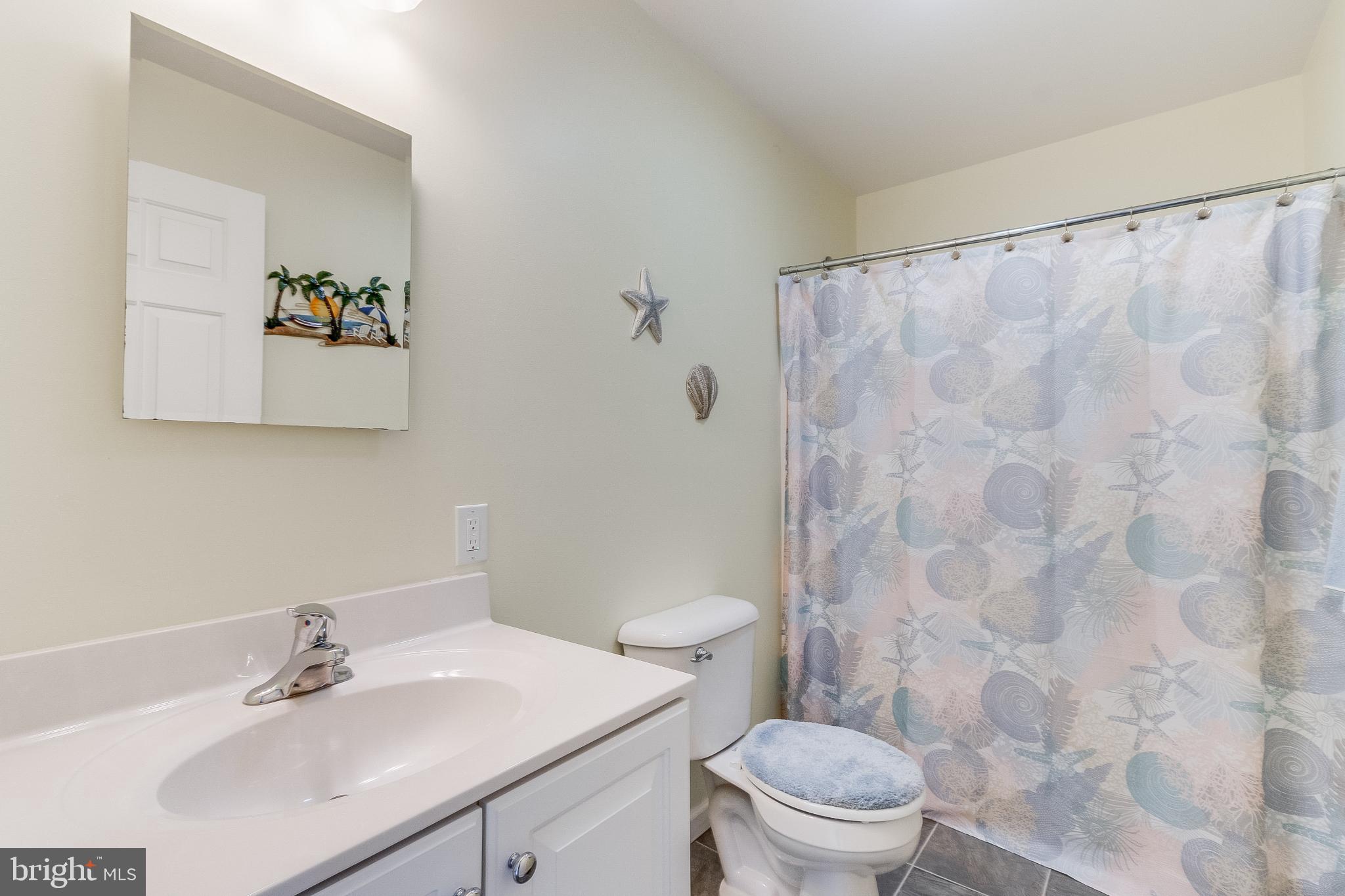 30147 Regatta Bay Boulevard Lewes, DE 19958 - Photo 52 of 74 a bathroom with a sink mirror and a toilet