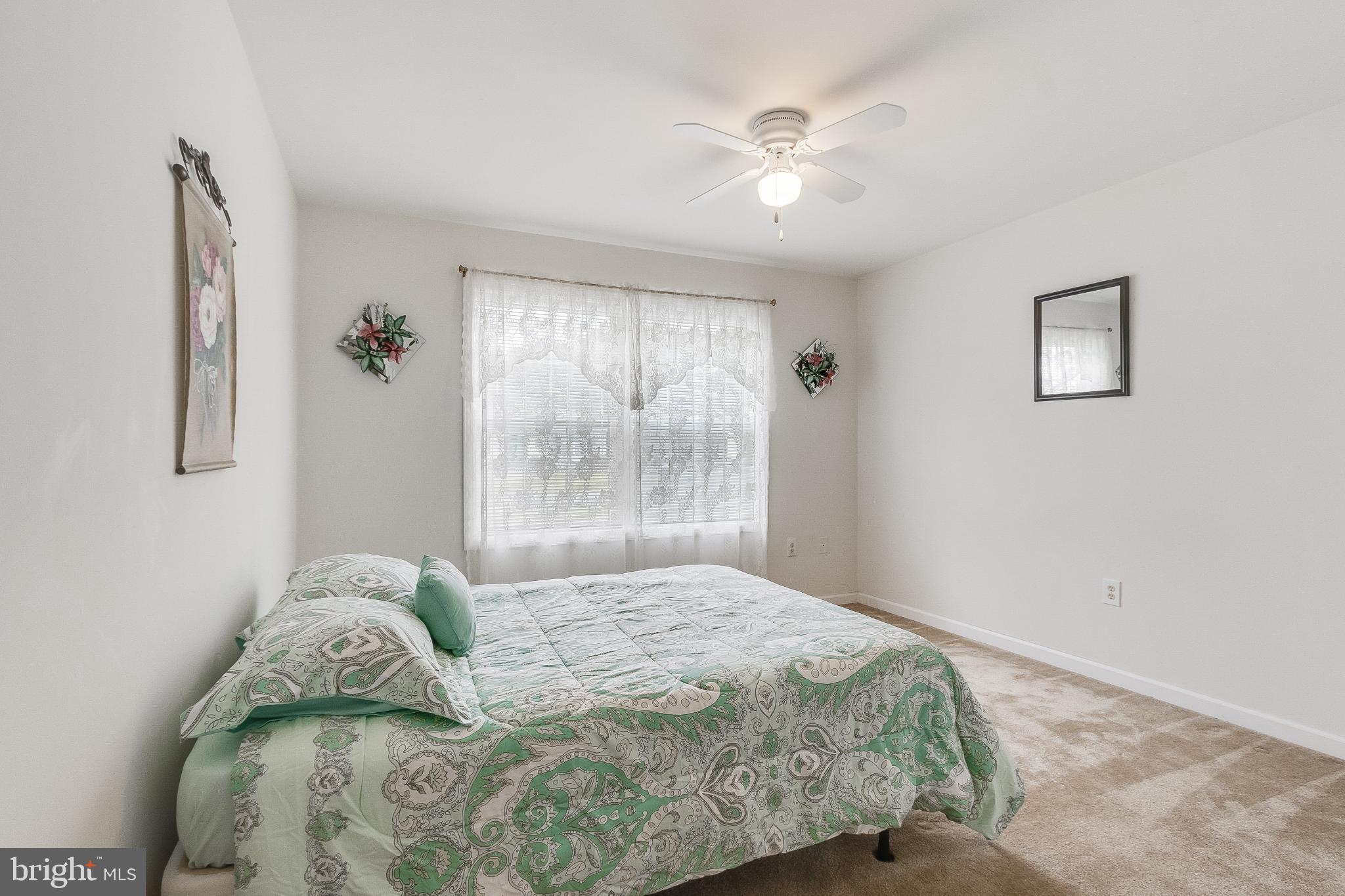 30147 Regatta Bay Boulevard Lewes, DE 19958 - Photo 53 of 74 a bedroom with a bed and a chandelier