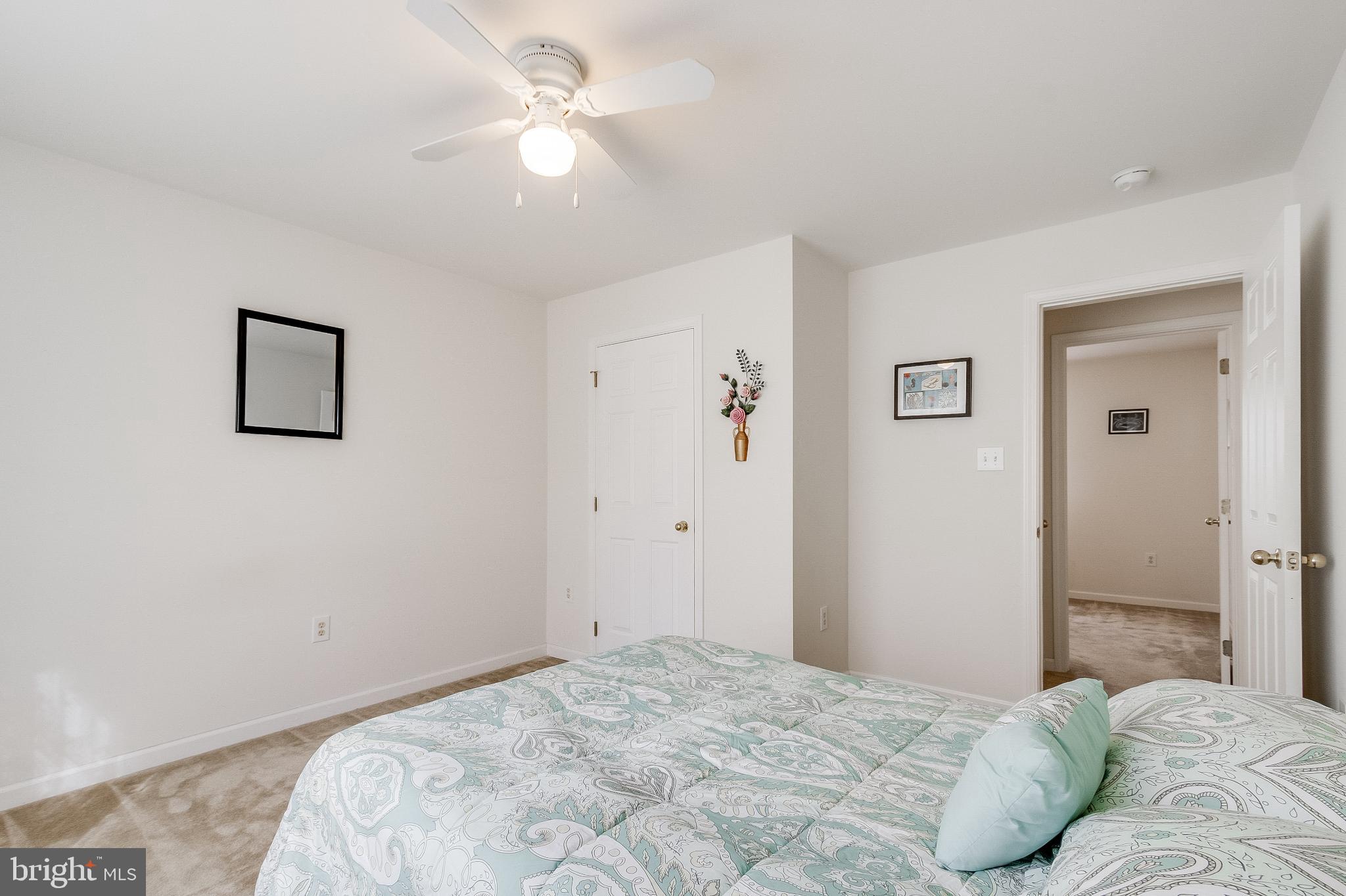 30147 Regatta Bay Boulevard Lewes, DE 19958 - Photo 55 of 74 a bedroom with a bed and a chandelier