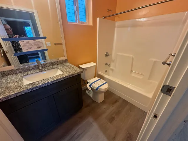 a bathroom with a granite countertop sink toilet and shower