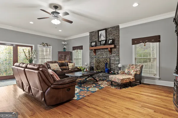 a living room with furniture fireplace and a large window