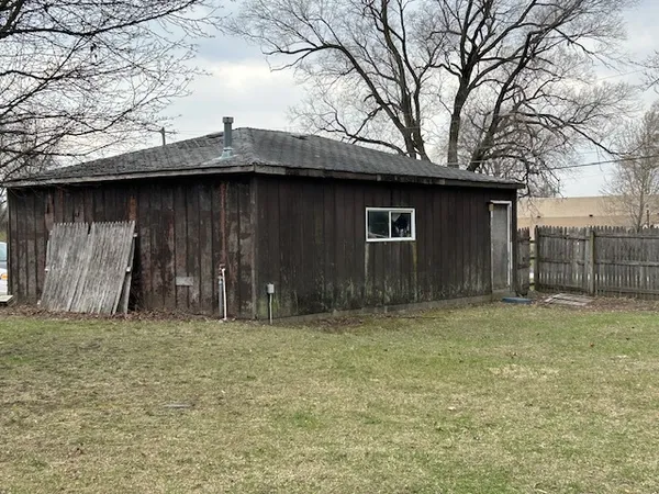 a view of a wooden house with a small yard