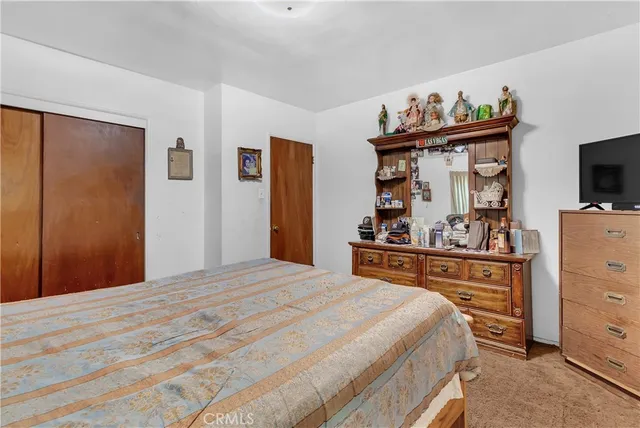 a bedroom with a bed and a flat tv screen in it