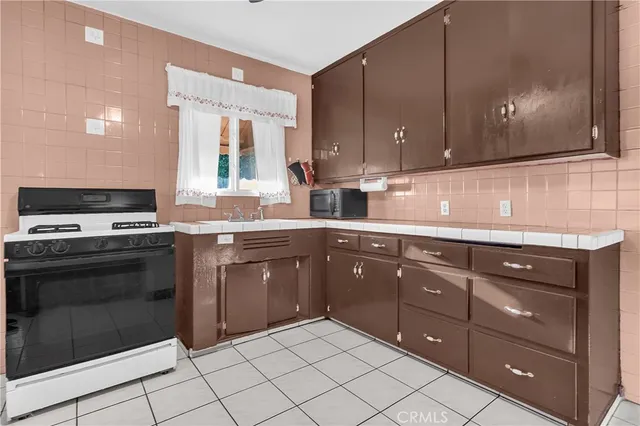 a kitchen with granite countertop a sink cabinets and stainless steel appliances