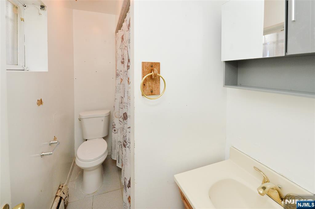 73 South Prospect Avenue Hackensack, NJ 07601 - Photo 24 of 28 a bathroom with a toilet sink and mirror