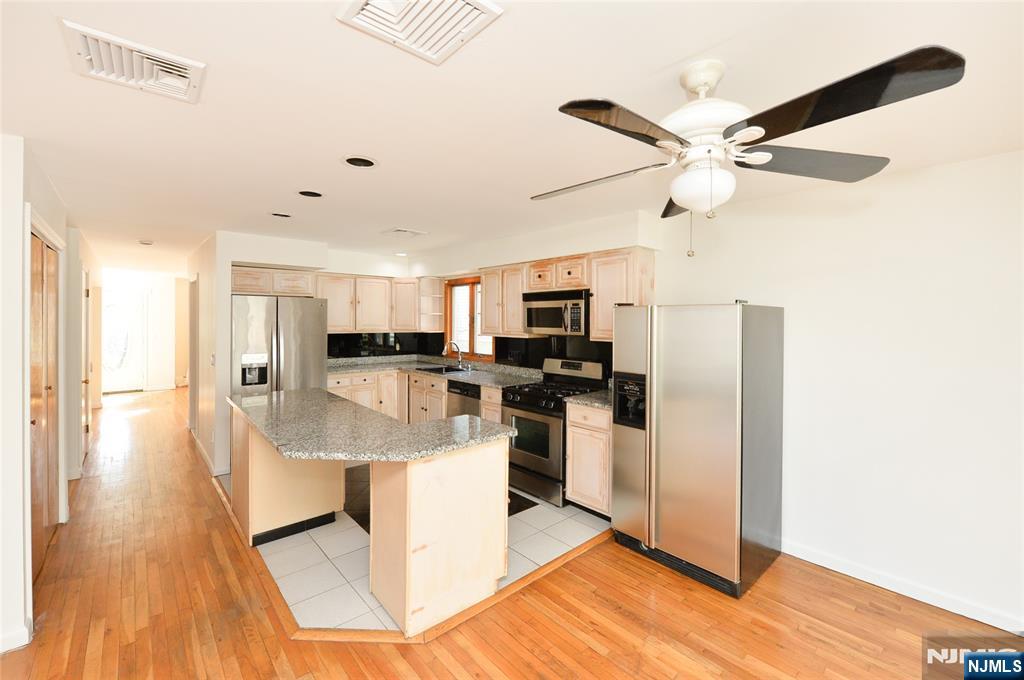 73 South Prospect Avenue Hackensack, NJ 07601 - Photo 6 of 28 a view of a kitchen with kitchen island stainless steel appliances refrigerator stove top oven and sink