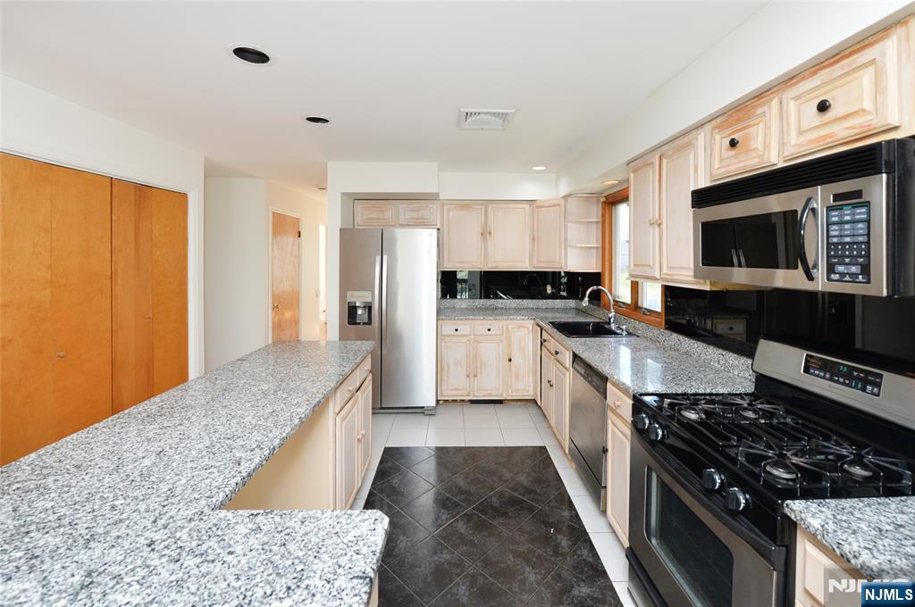 73 South Prospect Avenue Hackensack, NJ 07601 - Photo 8 of 28 a kitchen with stainless steel appliances granite countertop a stove a sink and a microwave