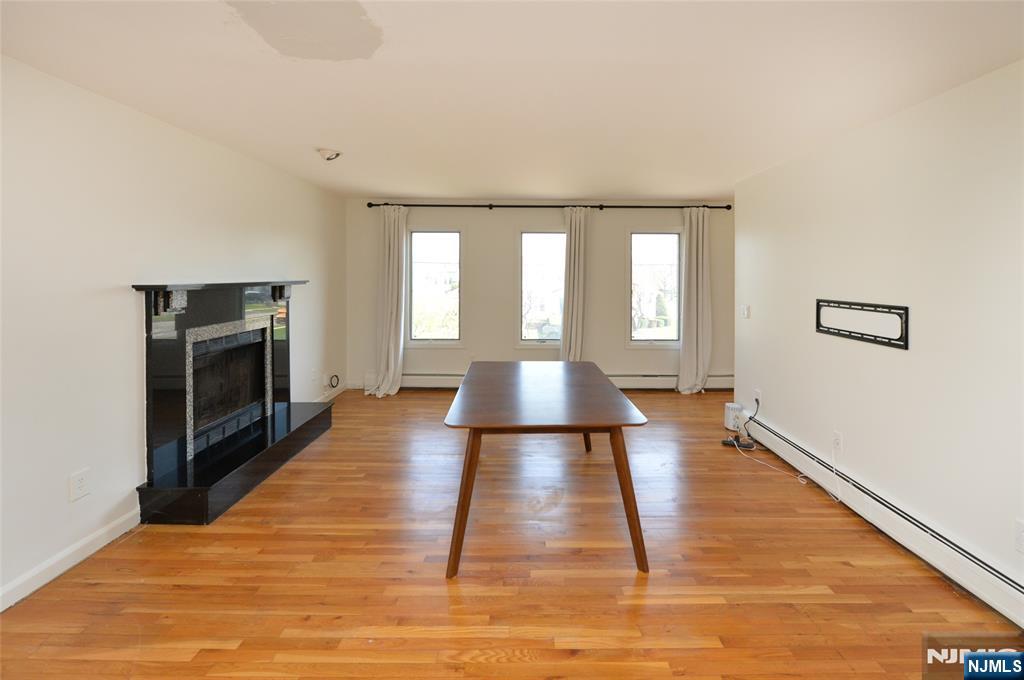 73 South Prospect Avenue Hackensack, NJ 07601 - Photo 9 of 28 a view of empty room with wooden floor and fireplace