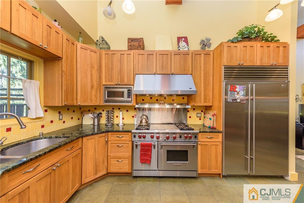 24 East Cliff Road Colonia, NJ 07067 - Photo 11 of 46 a kitchen with stainless steel appliances a stove a sink and a refrigerator