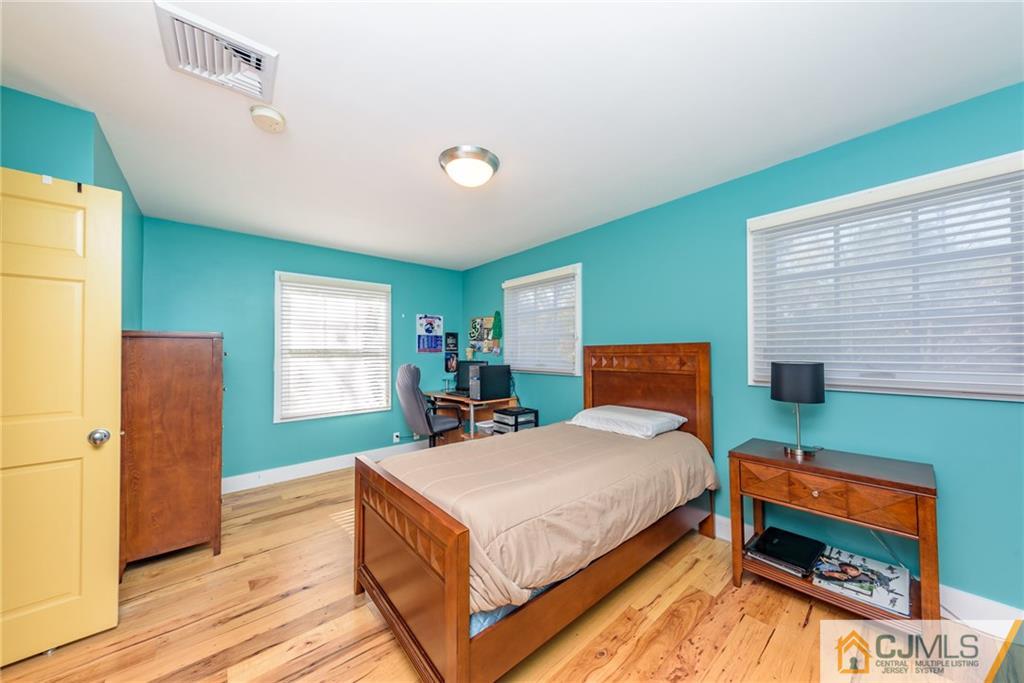 24 East Cliff Road Colonia, NJ 07067 - Photo 24 of 46 a bedroom with a bed and a dresser next to a window