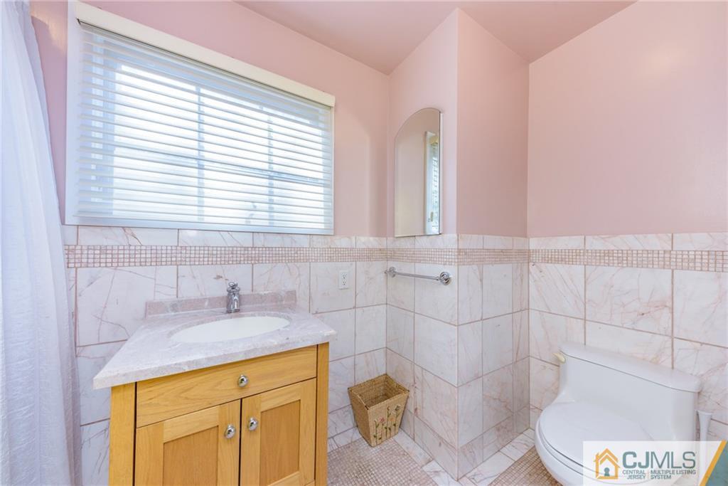 24 East Cliff Road Colonia, NJ 07067 - Photo 28 of 46 a bathroom with a sink a toilet and tub