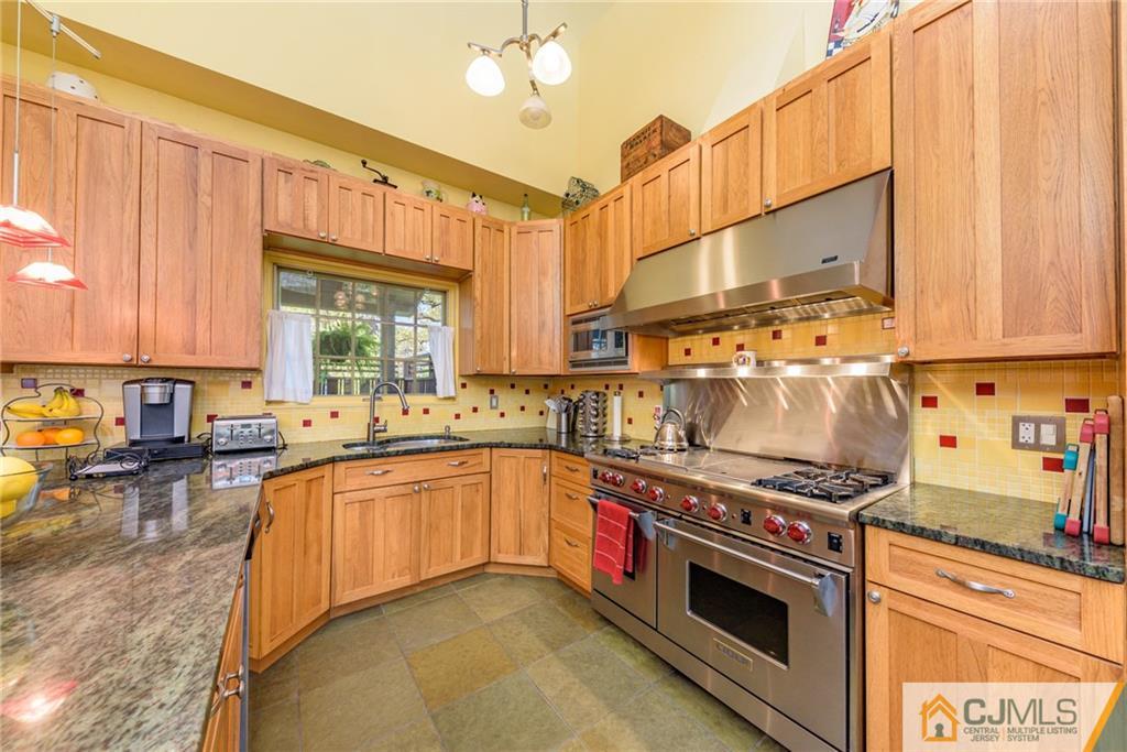 24 East Cliff Road Colonia, NJ 07067 - Photo 10 of 46 a kitchen with stainless steel appliances a stove a sink and cabinets