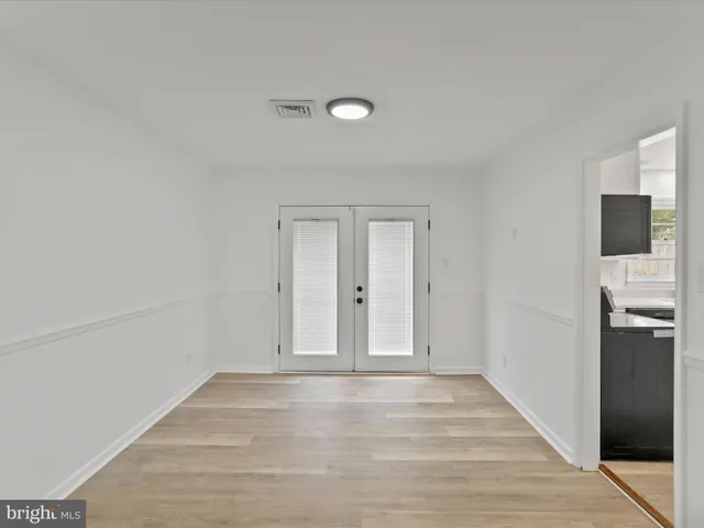 a view of empty room with wooden floor and electronic appliances