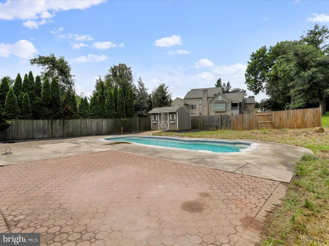 a view of swimming pool with a yard and wooden fence