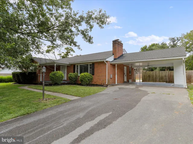 a view of a house with a yard and tree s