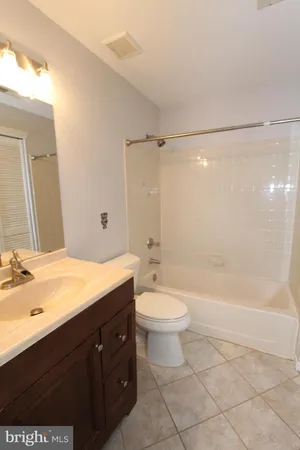 a bathroom with a bathtub shower sink mirror vanity and toilet
