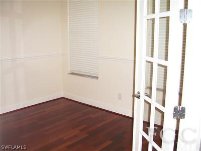 11620 Compass Point Drive Fort Myers, FL 33908 - Photo 4 of 10 an empty room with wooden floor and windows