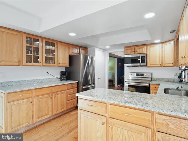 a kitchen with granite countertop stainless steel appliances a sink and counter space