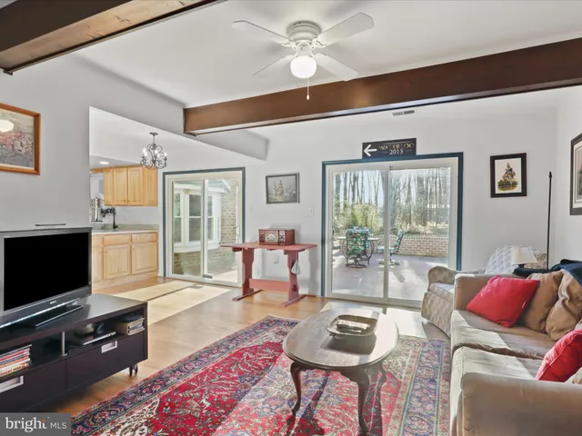 a living room with furniture a flat screen tv and a window