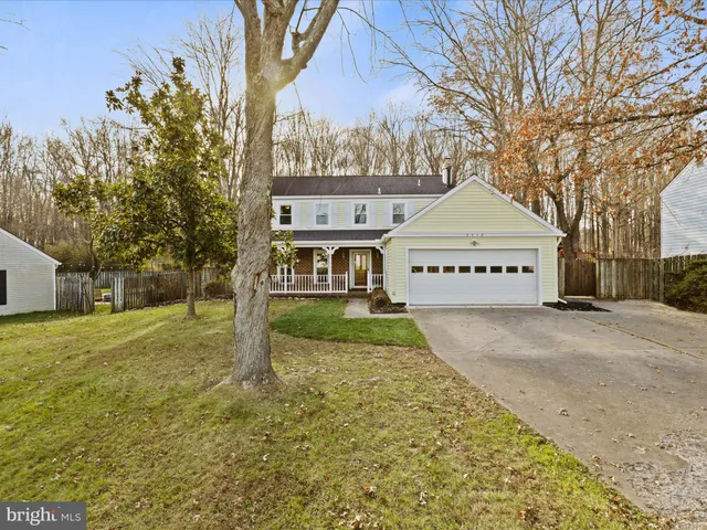 a view of a white house with a yard and large tree