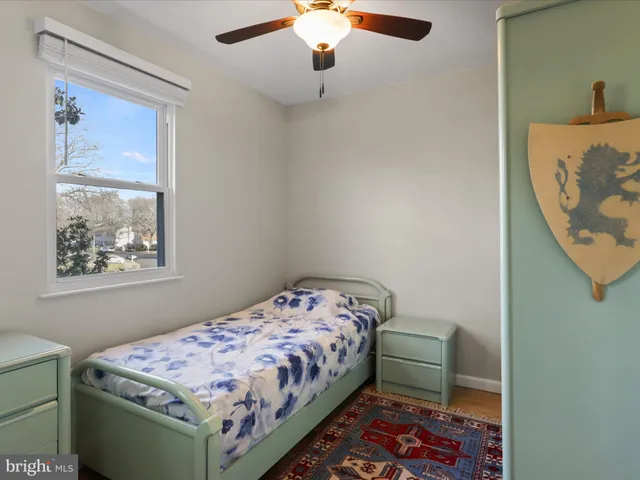 a bedroom with a bed and a lamp on dresser
