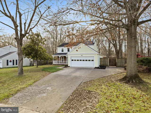 a view of a large white house with a yard covered with snow