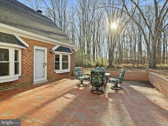 a view of a patio with table and chairs and floor to ceiling window