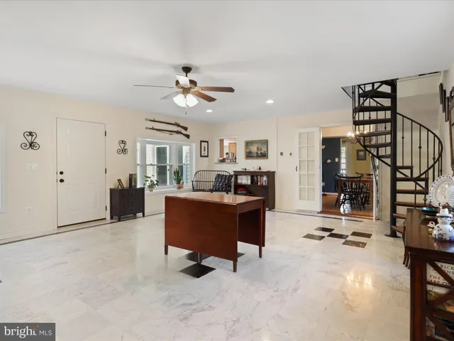 a living room with furniture cabinets and a ceiling fan