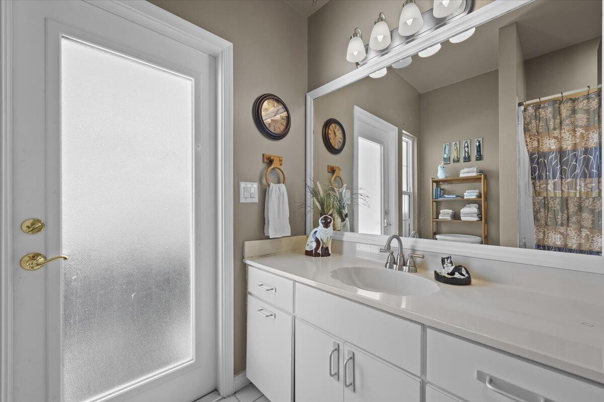 7 Alnwick Road Palm Beach Gardens, FL 33418 - Photo 20 of 47 a bathroom with a sink a mirror and a window
