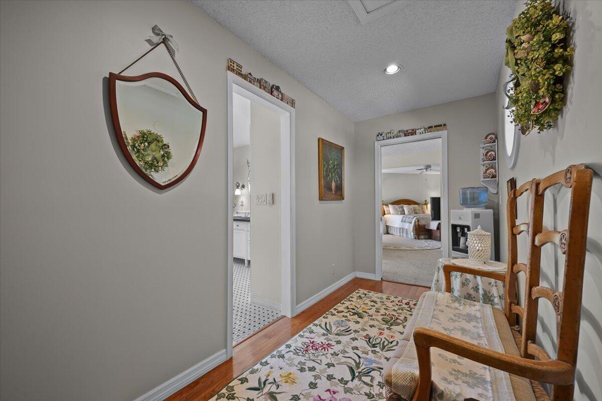 7 Alnwick Road Palm Beach Gardens, FL 33418 - Photo 22 of 47 a view of a hallway with wooden floor windows and a bathroom