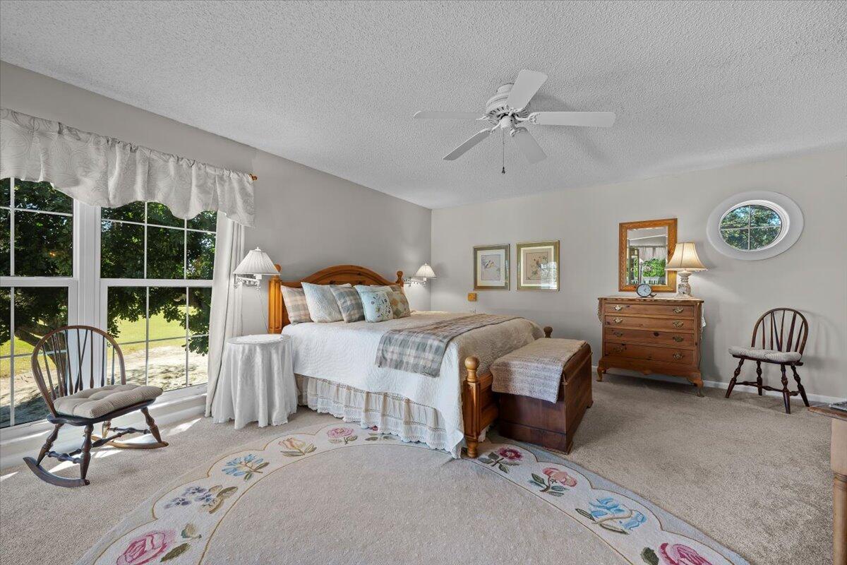 7 Alnwick Road Palm Beach Gardens, FL 33418 - Photo 25 of 47 a bedroom with a bed a couch and dresser