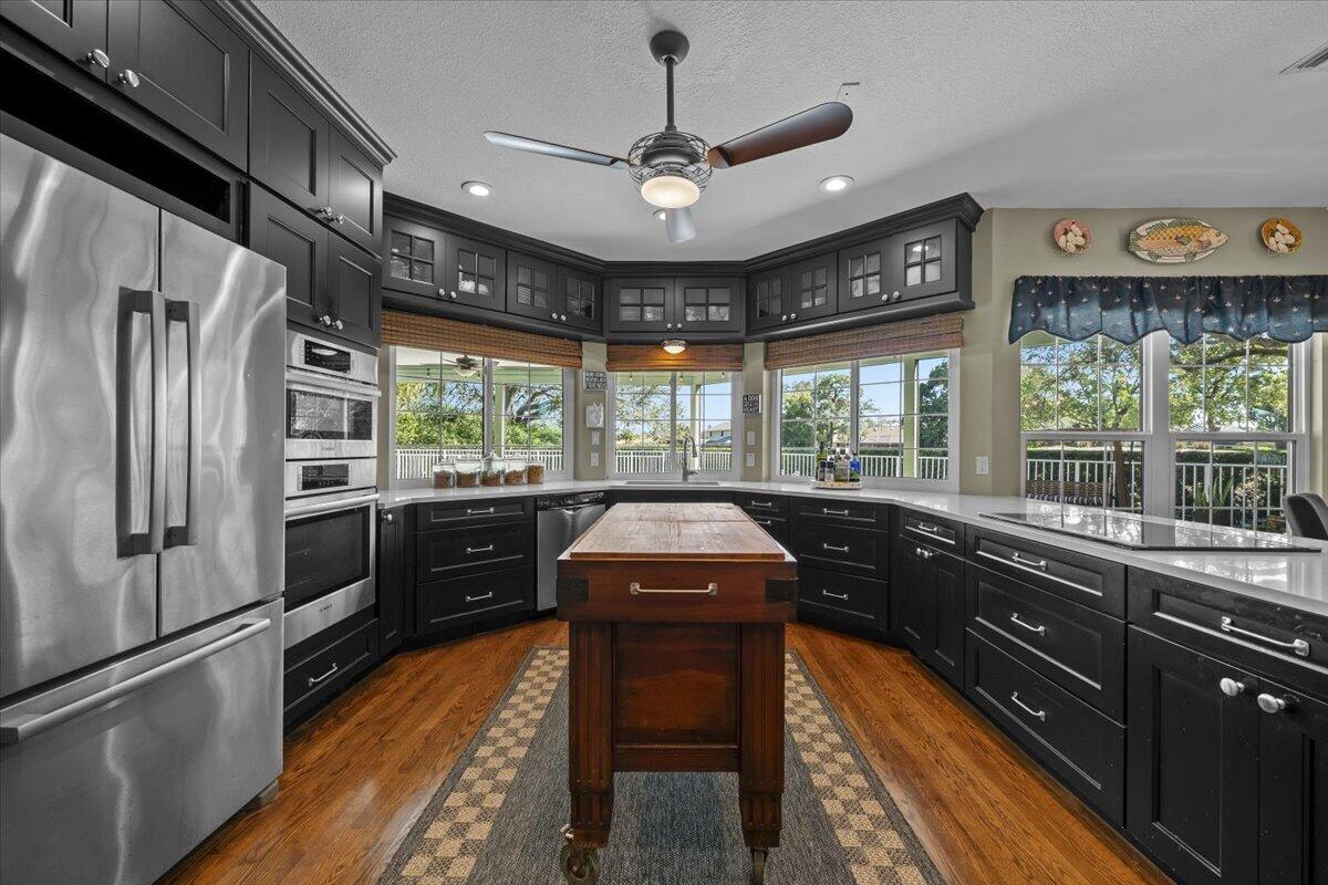 7 Alnwick Road Palm Beach Gardens, FL 33418 - Photo 8 of 47 a kitchen with stainless steel appliances granite countertop a refrigerator a sink dishwasher a stove and white countertops with wooden floor