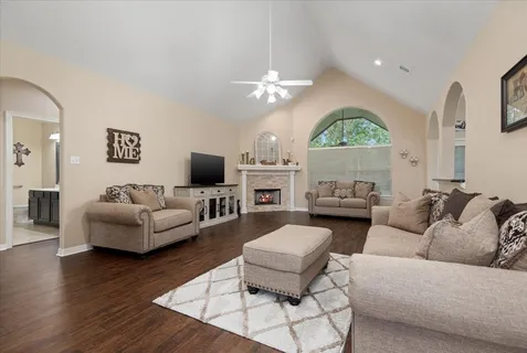 a living room with furniture a flat screen tv and a large window
