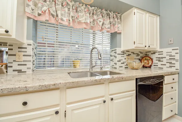 a kitchen with granite countertop a sink and a stove