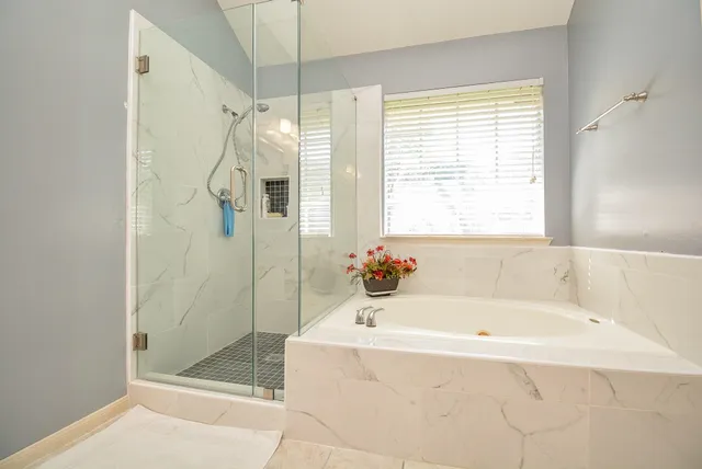 a white bath tub sitting next to a shower