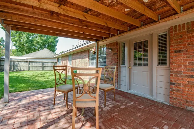 a patio with table and chairs and garden