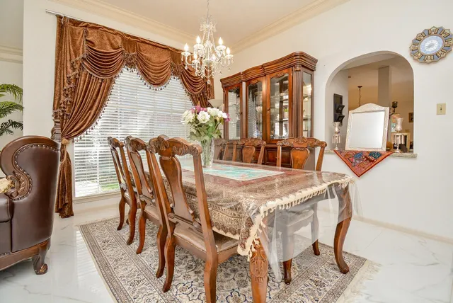 a view of a dining room with furniture and chandelier