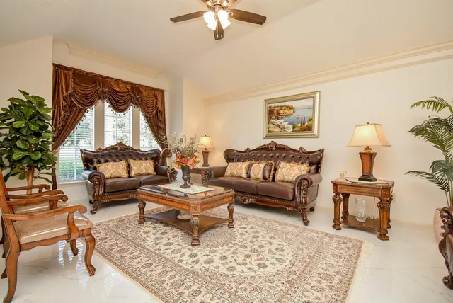 a living room with furniture and a large mirror next to a window